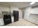 Kitchen features white cabinets, black appliances, and tile floors at 1600 Whisperwood Trl, Stone Mountain, GA 30088