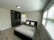 This bedroom features wood plank flooring, a window with blinds, and a built in closet at 1888 Peeler Rd, Atlanta, GA 30338