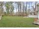 Expansive backyard featuring a large grassy lawn with mature trees and a view of the home at 3753 Adamsville Sw Dr, Atlanta, GA 30331