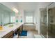 Bright bathroom features double sinks, tiled floor, a glass-enclosed shower, and a soaking tub at 4380 Serenity Lake Dr, Cumming, GA 30028