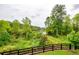 Scenic backyard with a black fence offering lush green vegetation, private path, and serene lake views at 4380 Serenity Lake Dr, Cumming, GA 30028