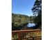 Scenic view of calm lake framed by lush trees as seen from deck with wooden railing at 4380 Serenity Lake Dr, Cumming, GA 30028