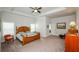 Spacious main bedroom features a tray ceiling, a wooden bed frame, carpeted floors, and natural light at 4380 Serenity Lake Dr, Cumming, GA 30028