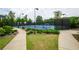 View of a well-maintained community tennis court with lush landscaping and paved walkway in a lovely setting at 4380 Serenity Lake Dr, Cumming, GA 30028