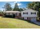 Ranch home with brick and white siding, attached garage, and a well-manicured lawn at 1022 Washington Ave, Woodstock, GA 30188