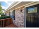 Brick front entrance with a black door, wooden deck, and keyless entry at 1022 Washington Ave, Woodstock, GA 30188