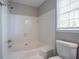 Bathroom with white tiled shower and tub, matching toilet and a window at 3500 Quinn Ridge Dr, Snellville, GA 30039