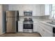 Modern kitchen featuring stainless steel appliances, bright white cabinets, and laminate flooring at 3500 Quinn Ridge Dr, Snellville, GA 30039