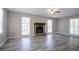Bright living room featuring a stone fireplace, large windows, and stylish laminate flooring at 3500 Quinn Ridge Dr, Snellville, GA 30039