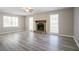 Spacious living room with cozy stone fireplace, three large windows, and modern laminate flooring at 3500 Quinn Ridge Dr, Snellville, GA 30039