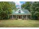 Two-story home with a green metal roof and a large front porch at 915 Rocky Creek Rd, Hampton, GA 30228