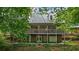 Two-story home with wraparound deck and green roof at 915 Rocky Creek Rd, Hampton, GA 30228