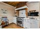 Rustic kitchen with wood-paneled walls, a copper range hood, and stainless steel appliances at 915 Rocky Creek Rd, Hampton, GA 30228