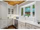 White kitchen with farmhouse sink, white cabinets and wood ceiling at 915 Rocky Creek Rd, Hampton, GA 30228