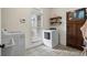 Bright laundry room with washer, dryer, and built-in shelves at 915 Rocky Creek Rd, Hampton, GA 30228