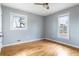 This bedroom features hardwood floors, neutral paint, baseboard heating, and two windows at 118 Wheelan School Rd, Dallas, GA 30157