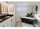 Modern bathroom featuring a dual sink vanity, black soaking tub, and elegant fixtures at 1470 S Gordon Sw St, Atlanta, GA 30310