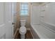 This bathroom features white fixtures, a window, and white tiled shower and tub at 270 Merrydale Dr, Fayetteville, GA 30215