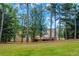 House nestled in a wooded backyard with a large grassy area at 1456 Reagan Nw Cir, Conyers, GA 30012