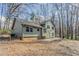 View of the green siding and backyard of this charming two-story home surrounded by trees at 265 N Fayette Ct, Fayetteville, GA 30214