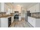 Well-lit kitchen with white cabinets, stainless steel appliances, granite countertops and modern backsplash at 265 N Fayette Ct, Fayetteville, GA 30214