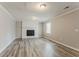 Cozy living room featuring a brick fireplace, neutral walls, crown moulding, and wood-look floors at 265 N Fayette Ct, Fayetteville, GA 30214