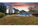 Peaceful backyard at dusk featuring a kidney-shaped pool at 521 James Ridge Ln, Stockbridge, GA 30281