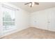 Bright bedroom featuring neutral carpeting, a large window, and access to a closet and the hallway at 5672 Kingsport Dr # 4, Atlanta, GA 30342