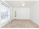 Neutral carpeted bedroom featuring a window, ceiling fan, and a mirrored closet door at 5672 Kingsport Dr # 4, Atlanta, GA 30342