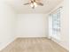 Well-lit bedroom featuring neutral carpeting, a ceiling fan, and a large window at 5672 Kingsport Dr # 4, Atlanta, GA 30342