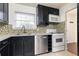 Well-lit kitchen featuring stainless steel appliances, modern cabinetry, and stylish mosaic tile backsplash at 5672 Kingsport Dr # 4, Atlanta, GA 30342