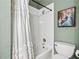 Bathroom featuring a tiled shower with decorative curtain and a white toilet at 1302 Turtlebrook Ln, Lawrenceville, GA 30043