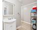 Neutral powder room featuring a single vanity sink, a mirror, and a small open storage shelf at 1302 Turtlebrook Ln, Lawrenceville, GA 30043