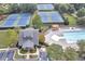 Aerial view of community amenities including tennis courts, a sparkling pool, and a clubhouse with lush landscaping at 1302 Turtlebrook Ln, Lawrenceville, GA 30043