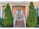 Inviting front entrance with brick steps, decorative pillars, and well-manicured evergreens at 1302 Turtlebrook Ln, Lawrenceville, GA 30043
