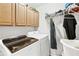 Convenient laundry area with washer, dryer, and wooden cabinets for ample storage space at 1302 Turtlebrook Ln, Lawrenceville, GA 30043