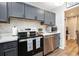 Modern kitchen with gray cabinets, stainless steel appliances, and stylish backsplash at 2251 Pernoshal Ct, Atlanta, GA 30338