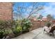 Private patio with seating, surrounded by landscaping and brick wall at 2251 Pernoshal Ct, Atlanta, GA 30338