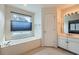 Bathroom featuring a tub with a window and a vanity with a sink at 10965 Glenbarr Dr, Johns Creek, GA 30097