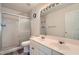 Bathroom featuring dual sinks, marble tiling, and a glass shower door at 10965 Glenbarr Dr, Johns Creek, GA 30097