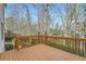 Spacious deck with wooden railing, overlooking a treed backyard at 10965 Glenbarr Dr, Johns Creek, GA 30097