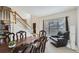 Dining room featuring hardwood table, leather chair, and staircase in background at 10965 Glenbarr Dr, Johns Creek, GA 30097