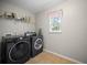 Laundry room equipped with modern washer and dryer, overhead shelving and window at 296 Cedar Bay Cir, Dallas, GA 30157