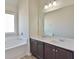 Bathroom vanity featuring double sinks, dark wood cabinetry, and decorative lighting at 7889 Winkman Dr, Fairburn, GA 30213