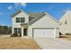 Charming two-story home with a two-car garage and well-maintained front yard with blue skies overhead at 7889 Winkman Dr, Fairburn, GA 30213