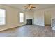 Bright living room features wood flooring, a ceiling fan, a fireplace, and large windows at 7889 Winkman Dr, Fairburn, GA 30213