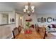 Dining room with wood floor, modern light fixture, and view of the living room at 1965 Nocturne Dr # 1205A, Alpharetta, GA 30009