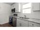 Bright kitchen featuring white cabinets, granite countertops, and stainless steel appliances at 327 Thornton Sw St, Atlanta, GA 30315