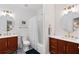 Stylish bathroom featuring a wood vanity, round mirror, and a shower/tub combination at 110 Mattison Cv, Atlanta, GA 30319