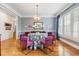 Elegant dining room with modern chandelier, hardwood floors, and bright windows with plantation shutters at 110 Mattison Cv, Atlanta, GA 30319